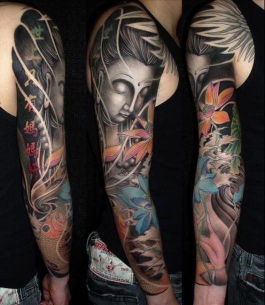 Tatuagem cobrindo o braço com um buda na parte superior e flores e carpas no antebraço