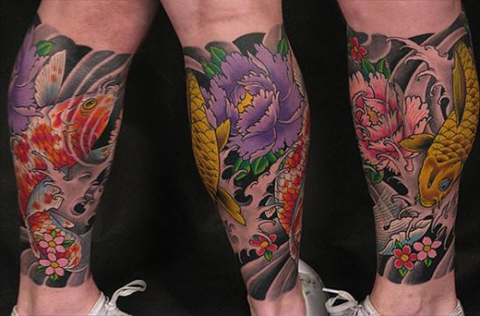 Tatuagem oriental na canela colorida com duas carpas e muitas flores