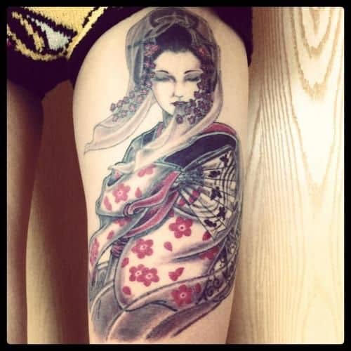 Tatuagem de uma gueixa ornamentada na perna de uma mulher 