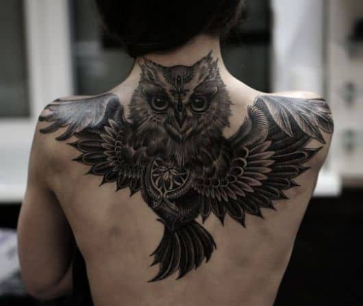 Tatuagem nas costas com o desenho de uma coruja voando