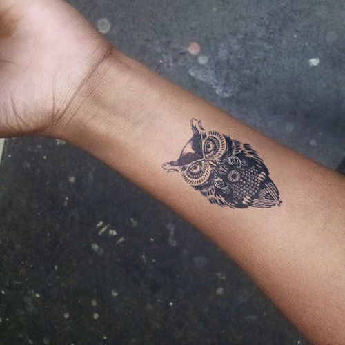 Tatuagem pequena de uma coruja feita no pulso 