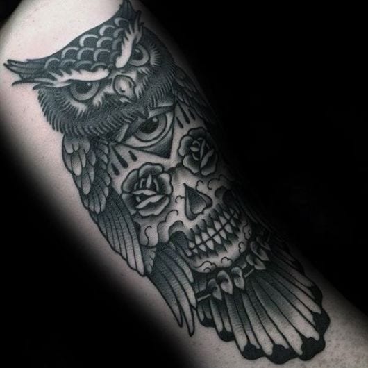Tatuagem de uma coruja com uma caveira mexicana incorporada ao seu corpo.