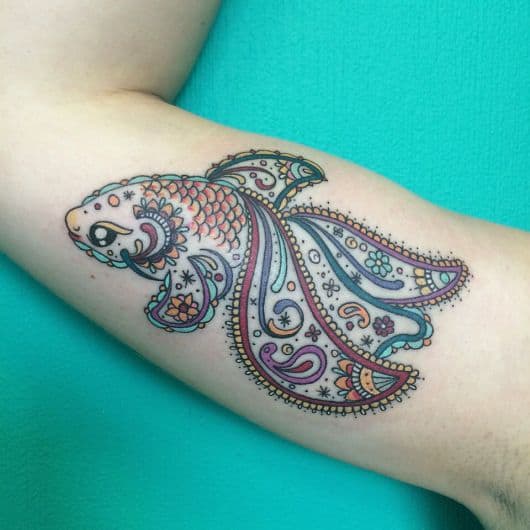 Tatuagem de uma peixe delicado com longas barbatanas e diversas cores em seu interior 