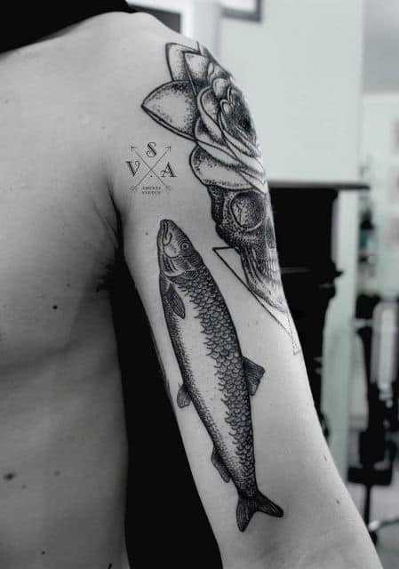 Tatuagem simples de um peixe apontando para cima feita no braço de um homem 
