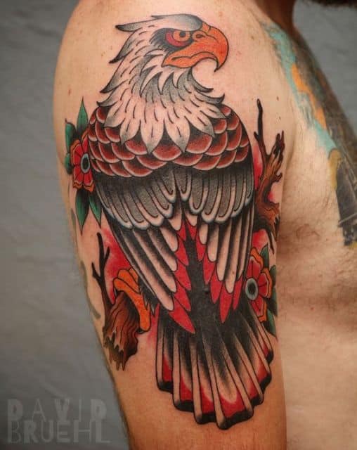 Tatuagem no ombro com o desenho colorido  de uma águia vista de costas olhando para o lado