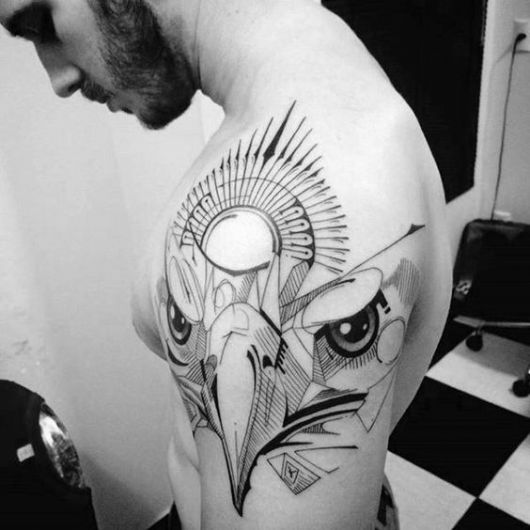 Tatuagem abstrata dos traços do rosto de uma águia feita no ombro de um homem 