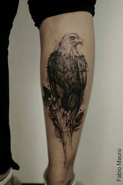 Tatuagem em preto e branco de uma águia olhando para o lado feita na panturrilha de um homem 
