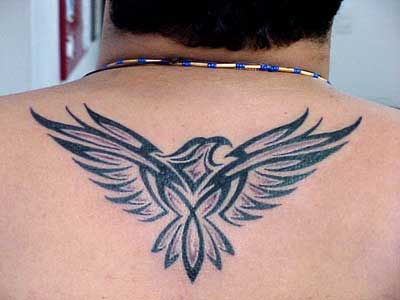 Tatuagem tribal de uma águia com as asas abertas feita na parte superior das costas de um homem 