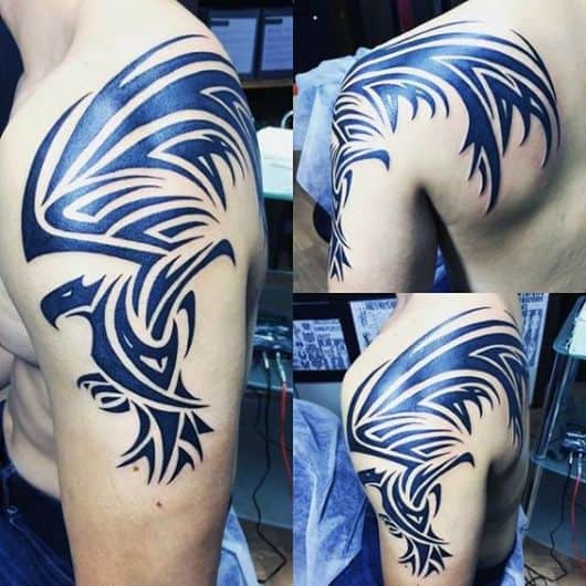 Tatuagem tribal grande no braço de um homem de uma águia vista de lado com as asas abertas e para cima 