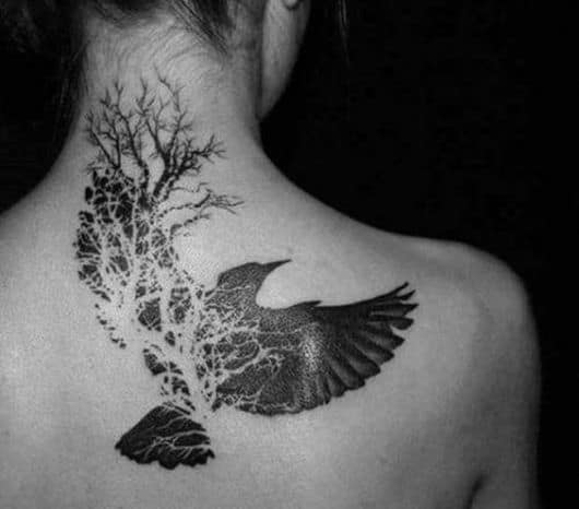 Tatuagem de uma águia alçando voo e parte dela se convertendo em uma árvore 