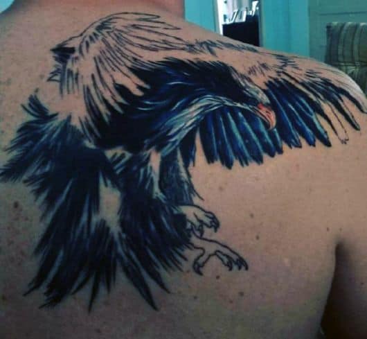 Tatuagem nas costas de uma águia com as asas abertas pronta para atacar
