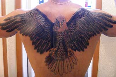 Tatuagem nas costas de uma águia com as asas abertas indo até o ombro do homem