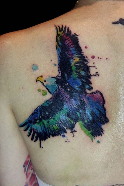 Tatuagem feita com aquarela de uma águia voando