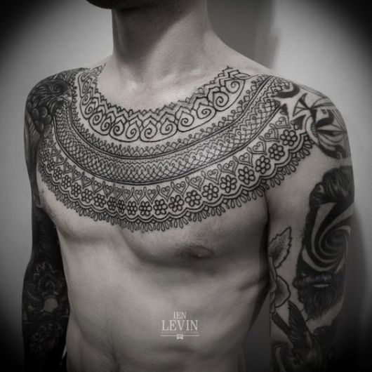 Tatuagem no peito de um homem feita a partir de diversas formas que simulam adornos egípcios. 