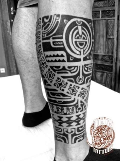 Tatuagem maori feita na canela com diversos símbolos intercalados. 