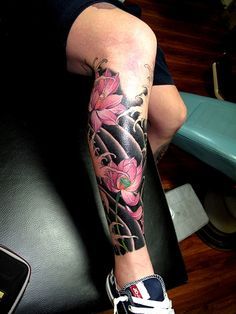 Tatuagem oriental na canela de algumas flores de cerejeira em um fundo preto. 