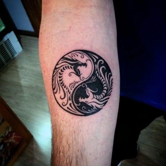 Tatuagem de Yin Yang com dois dragões em seu interior. Os dragões se opõem na posição e nas cores. 