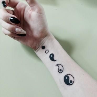 Tatuagem feita no pulso que sobe pelo braço. Nela é possível observar a desfragmentação do Yin Yang; em uma tattoo há o Yin Yang completo e nas outras pequenas partes separadas que o formam.