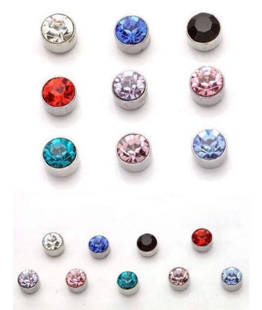 Foto de diversos brincos com pedras brilhantes de diferentes cores em um fundo branco.