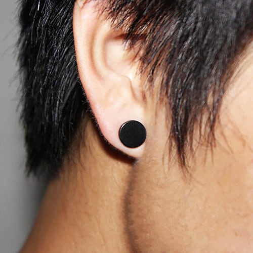 Foto tirada de perto da orelha de um homem que tem um brinco de pressão masculino preto.