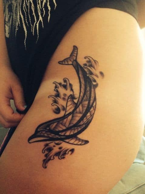 Tatuagem de golfinho feita em tons de cinza com o interior do animal coberto por linhas retas 