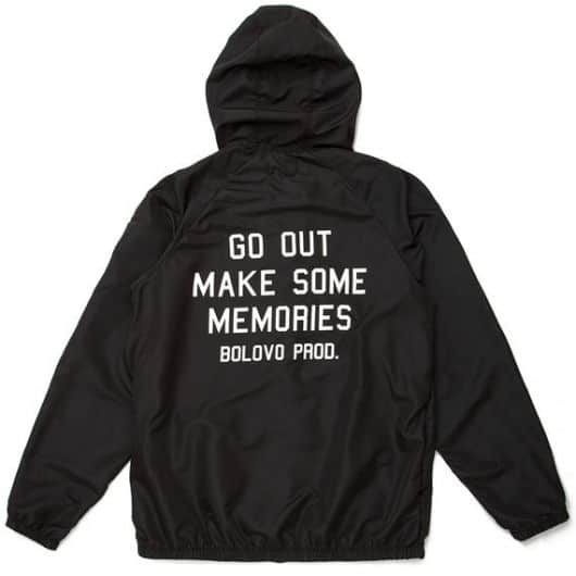 Foto da parte de trás de uma jaqueta de nylon masculina com a frase "Gou Out Make Some Memories" estampada. 
