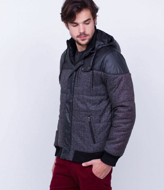 Homem de perfil olhando para baixo vestindo uma jaqueta com tecido de nylon na parte superior e algodão no resto. 