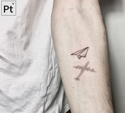 Tatuagem de avião de papel voando e sua sombra é a de um avião real. 