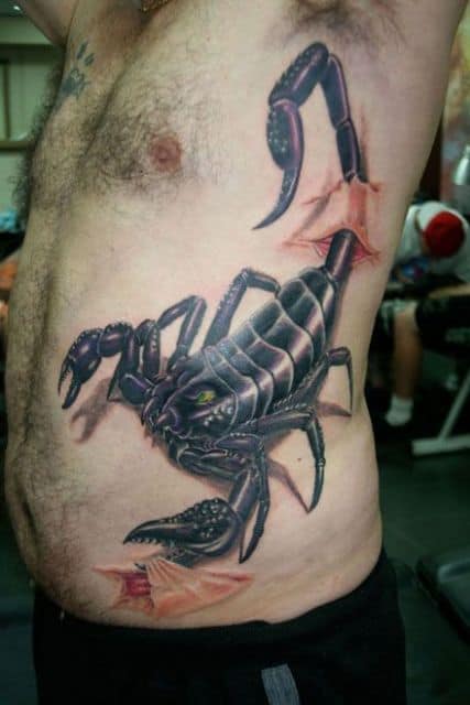 Tatuagem de escorpião na costela com suas garras e ferrão rasgando parte da pele, que é desenhada como se estivesse se desprendendo do corpo. 