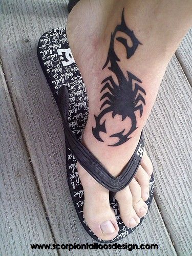 Tatuagem tribal toda pintada de preto feita na lateral do pé de um homem. 