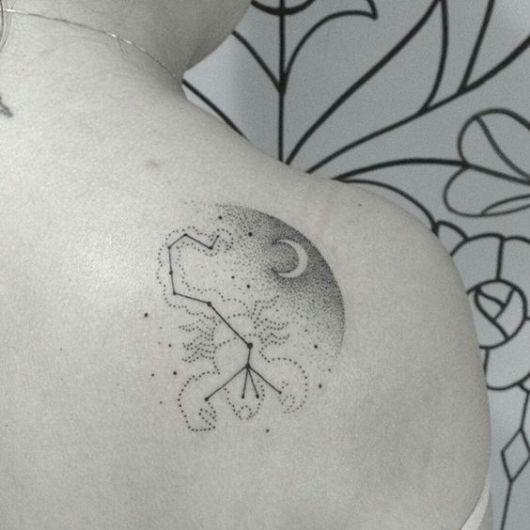 Tatuagem na lateral das costas em preto e branco da constelação de escorpião. 