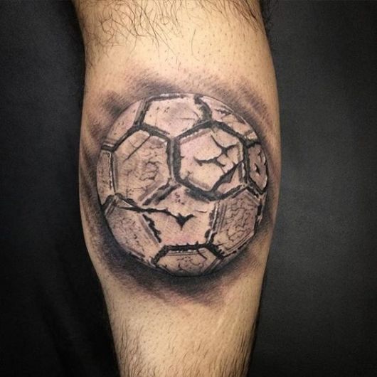 Tatuagem de uma bola de futebol desgastada. 