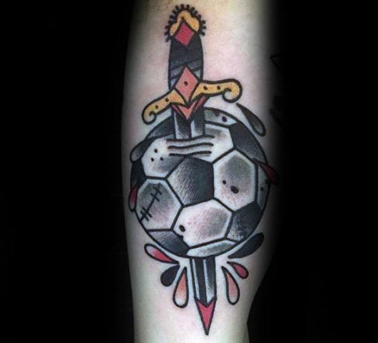 Tatuagem de uma bola de futebol sendo atravessada por um punhal no estilo tradicional.