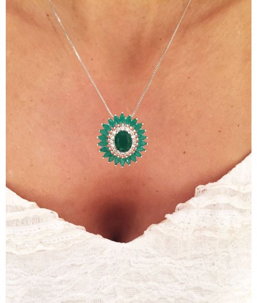 Mulher usa colar com corrente de prata e pedra verde cravejado em sua volta com esmeraldas e pedrinhas transparentes de zircônia.