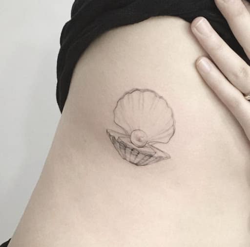 tatuagem de concha delicada na costela