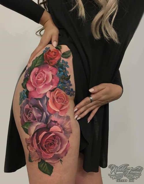 Tatuagem grande de rosas coloridas na coxa