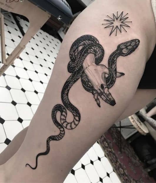 Cobra e mão em tatuagem.