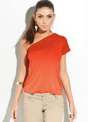 Modelo usa calça bege e blusa de um ombro só na cor laranja vibrante.