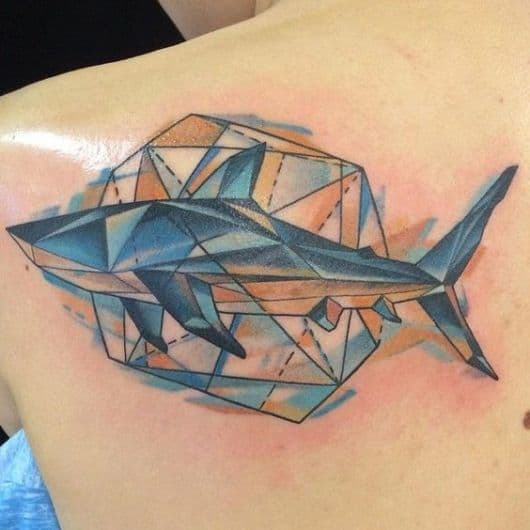 Tatuagem na lateral das costas com um tubarão feito a partir de formas geométricas e um grande hexágono atrás dele. 
