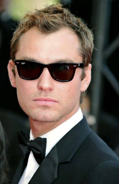 O ator Jude Law vestindo um traje característico das premiações de cinema acompanhado de um óculos quadrado masculino da Ray-Ban. 