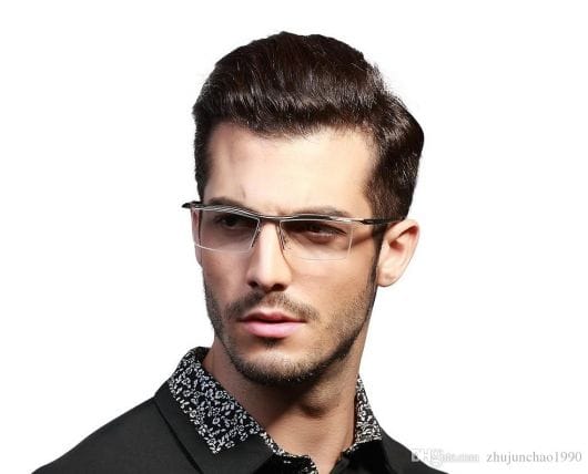 Homem de camisa social e cabelo penteado usando um óculos de grau quadrado discreto com hastes transparentes. 