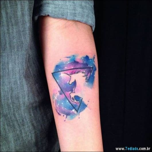 Tatuagem de unicórnio azul e rosa.