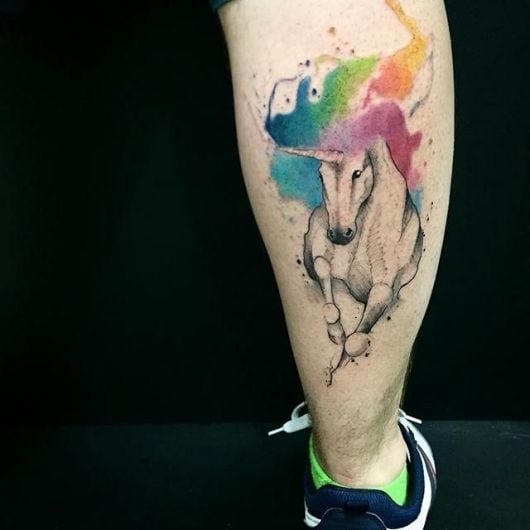 Tatuagem unicórnio colorida nas cores, rosa, amarelo, azul e verde.