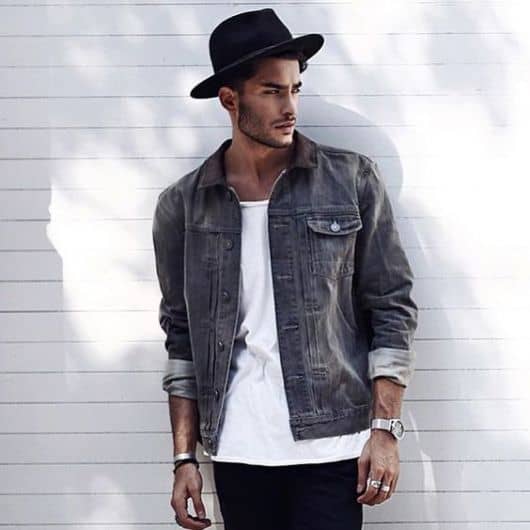 Modelo usa chapéu fedora preto, camisa jeans, blusa branca e calça preta.