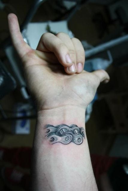 Tatuagem pequena de uma corrente feita no pulso. 