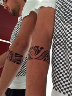Homem com uma tatuagem maori 360º no antebraço que forma uma espécie de bracelete. 
