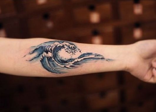 Tatuagem de uma onda se formando feita no antebraço de uma mulher. 
