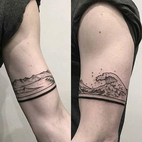 Tatuagem cobrindo uma linha de 360º no braço de um homem. Na parte interna vemos a terra e as montanhas; na parte externa vemos ondas altas de formando. 
