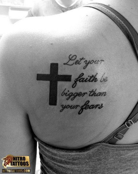 Tatuagem de uma frase nas costas de uma mulher escrito "Let Your faith be bigger than your fears" ao lado de uma cruz.