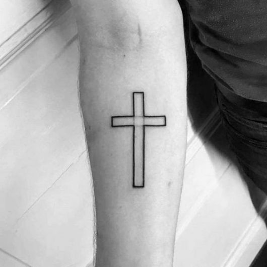 Tatuagem das linhas que formam uma cruz no antebraço de um homem. 
